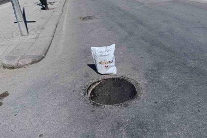 Çöken rögar kapağını gören vatandaş poşetle önlem aldı