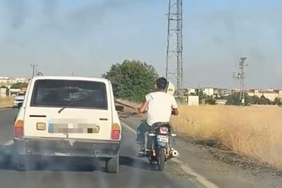 Otoyolda tehlikeli yolculuk: Motosiklet, otomobil kemerine tutunarak ilerledi