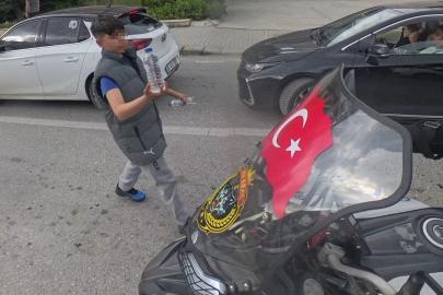 Su satan çocuk, camında Türk bayrağı olan motosikletliye su hediye etmek istedi
