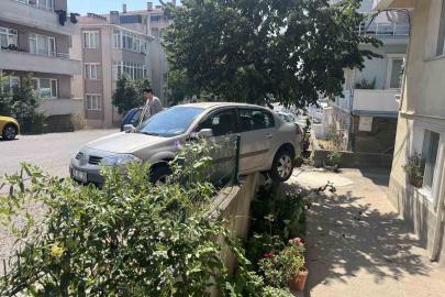 El frenini çekmeyi unuttu, otomobil bahçe duvarında asılı kaldı