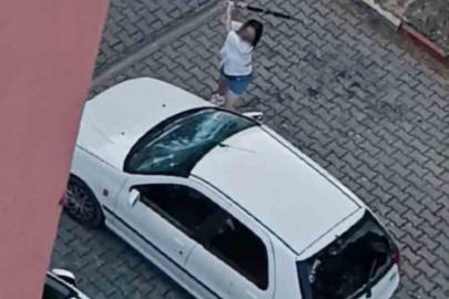 Park halindeki otomobilin camlarını kıran kadın kamerada