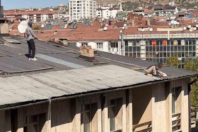 Çatıda oluk temizliği yapan şahıs, beline halat bağlayarak güvenlik önlemi aldı