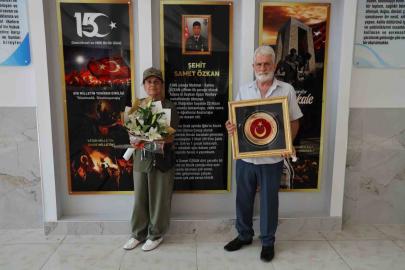 Şehit anne ve babası Türk bayrağıyla okulda