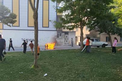 Sokaktaki koltuğu ateşe veren çocuklar sonra söndürmeye çalıştı