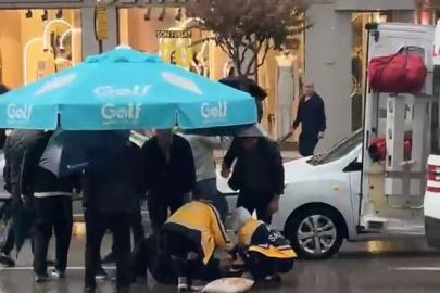 Yolun karşısına geçerken otomobil çarptı: Vatandaşlar yaralıya şemsiye tuttu