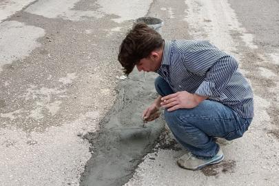 Çukurlu yolu vatandaşlar beton dökerek düzeltmeye çalıştı