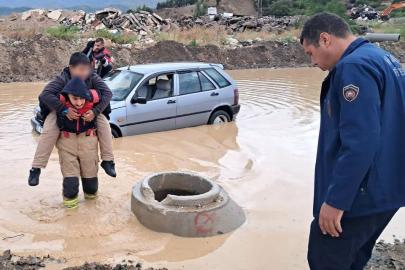 İtfaiyeci, göle dönen yolda mahsur kalan çocuğu sırtında taşıyarak kurtardı