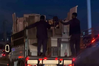 Kendi güvenliklerini değil, eşyaların güvenliğini sağlayarak kamyonetin arkasına tutundular