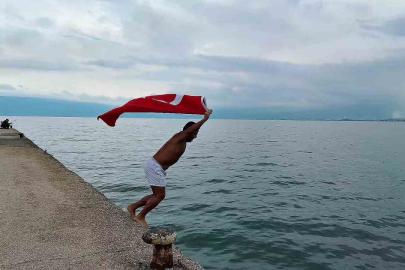 Soğuk ve yağışlı havaya aldırmadı, Türk bayrağıyla denize girdi