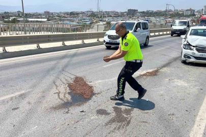 Trafik güvenliğini sağlamak amacıyla yağ dökülen yola avuçlarıyla kum taşıyan polis takdir topladı