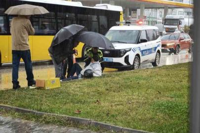 Yağmur altında ıslanan yaralıya trafik polisi şemsiye tuttu